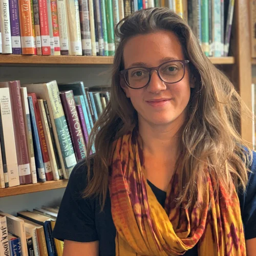 Laura Rovi standing in front of a bookshelf at the library
