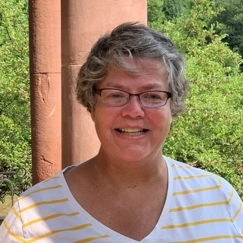 Mary Lynch standing outside in a sunny day smiling