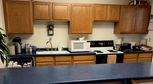 kitchen Photo of the kitchen with dishwasher, sink, microwave oven, range oven and coffee making supplies.