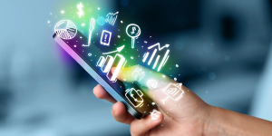 A hand holding a smartphone with colorful digital icons floating above the screen.