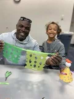 Father and daughter smiling and showing their macramé art