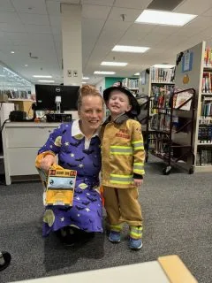 Mother and son in Halloween costumes. Boy is  a fireman, mother is a witch